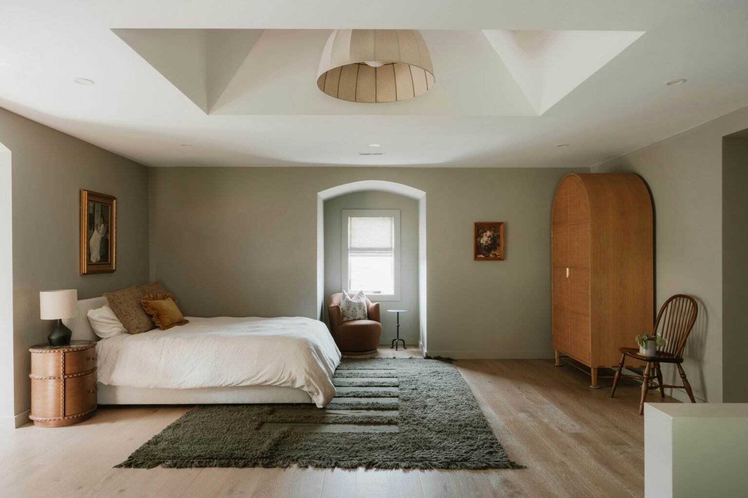 4x6 gray shag rug style idea: a shaggy rug laid at the foot of a white bed in a bright, neutral bedroom with wood floors