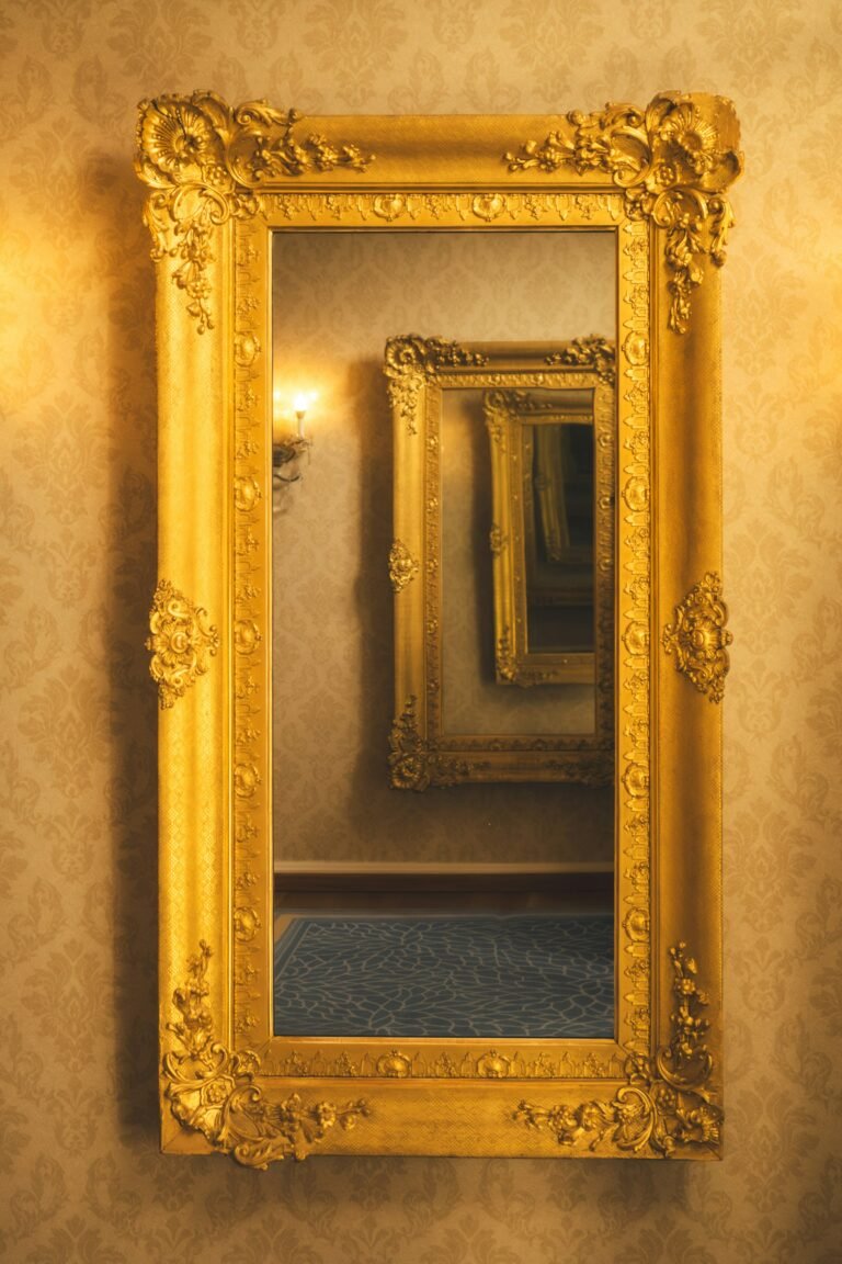 Close-up of a gold arched floor mirror frame on a wall