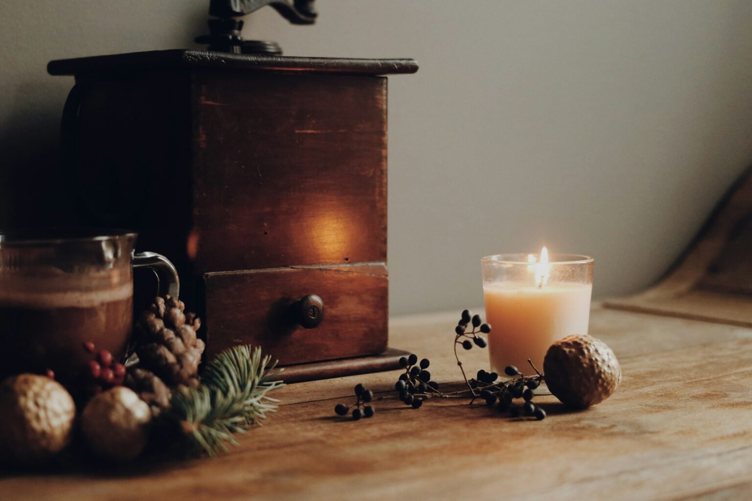 Apple pie candle mood: a lit jar candle glowing beside a wooden drawer
