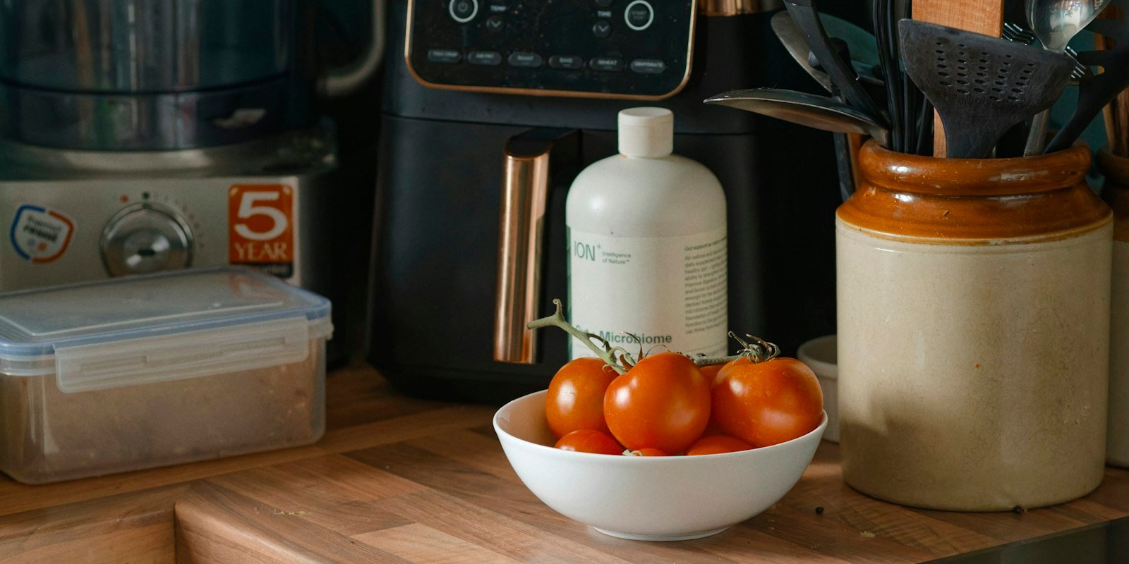 Best air fryer for family meals on a wooden kitchen counter next to fresh tomatoes