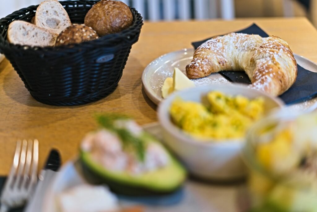 Breakfast table with a bread basket, croissant and a pat of butter, the kind of spread a butter dish with lid keeps ready