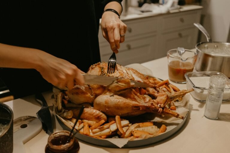 Best carving knife for turkey in use: a host slices a roast turkey with a carving knife and fork at the holiday table