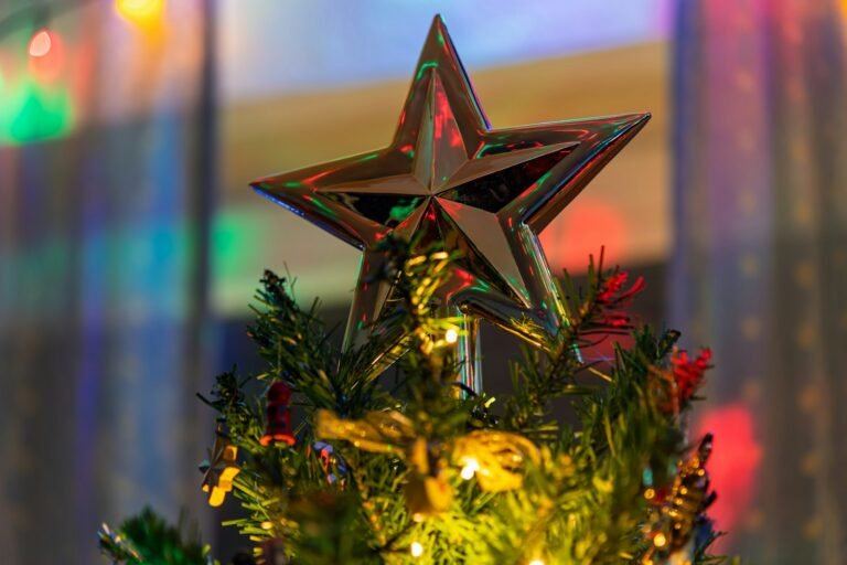 Best Christmas tree toppers: a shiny gold star on top of a lighted tree