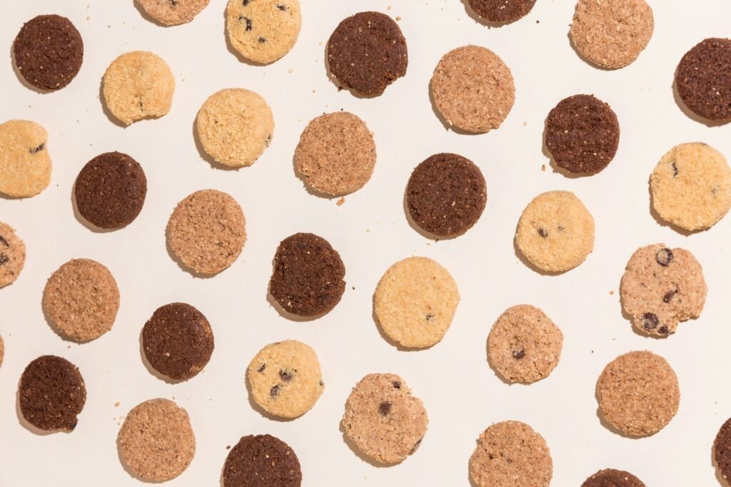 Best cookie press results: rows of round pressed butter cookies in vanilla and chocolate on a light counter
