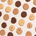 Best cookie press results: rows of round pressed butter cookies in vanilla and chocolate on a light counter