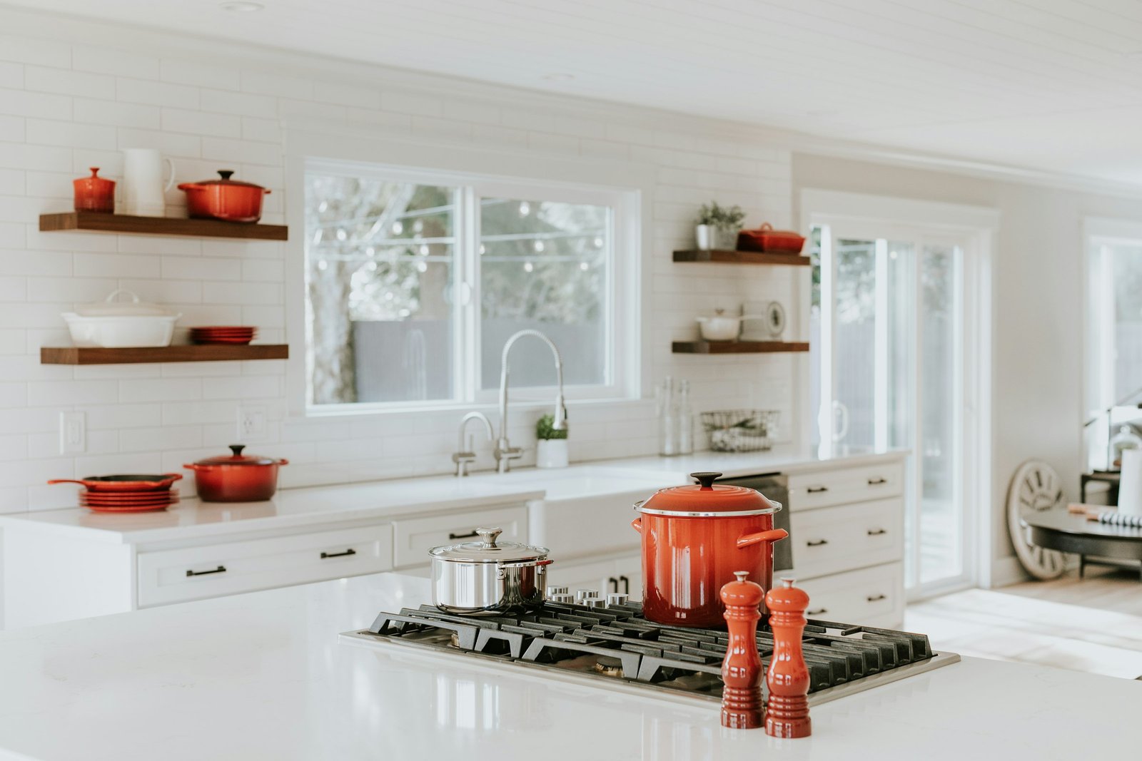 Best cookware sets guide: stainless and enameled pots on a gas cooktop in a bright white kitchen