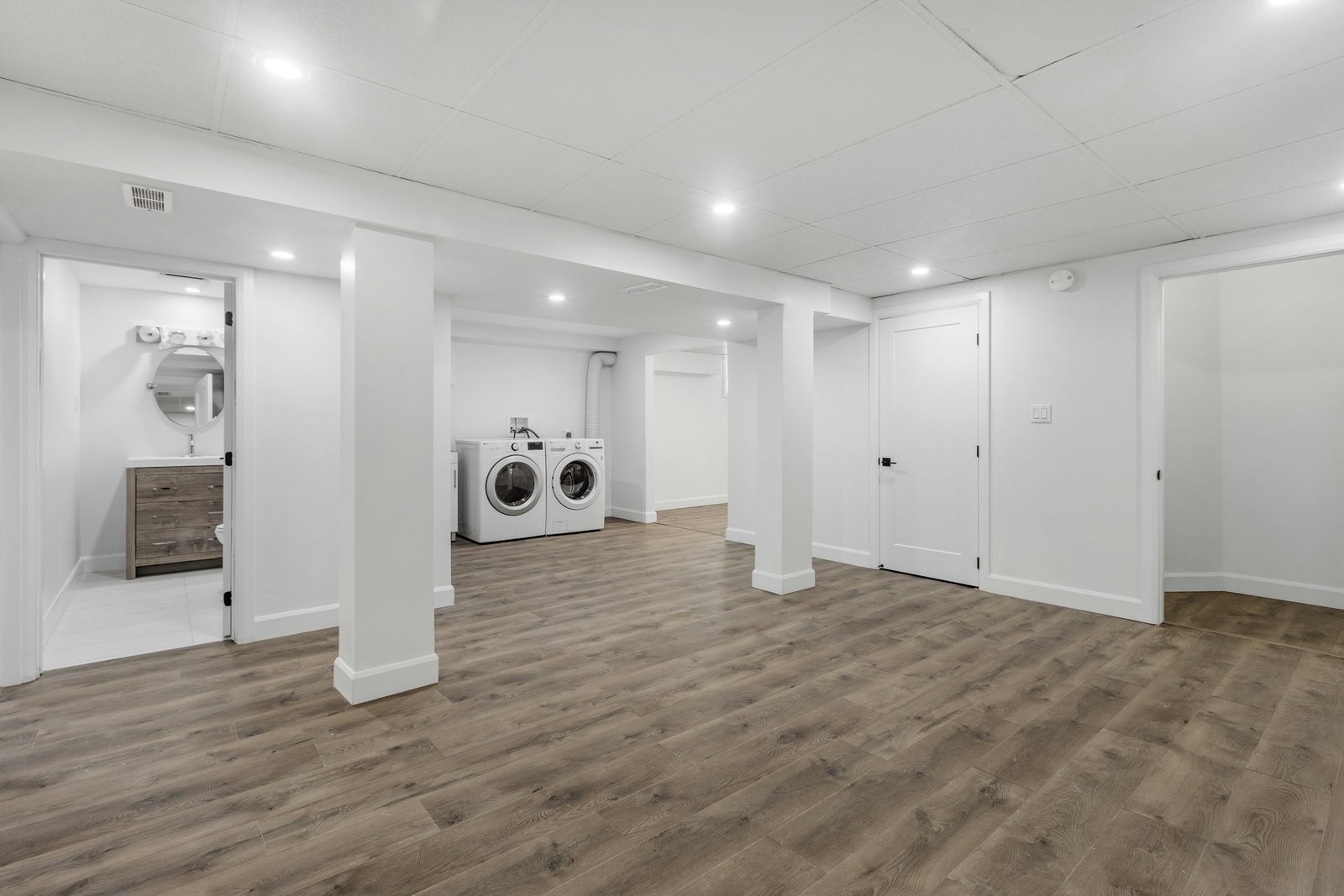 Best dehumidifier for basement spaces: a bright finished basement with laundry area and vinyl plank floors