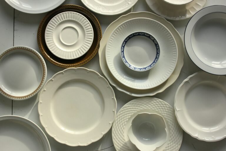 Best dinnerware sets: white stoneware and porcelain dinner plates, salad plates and bowls laid out on a table