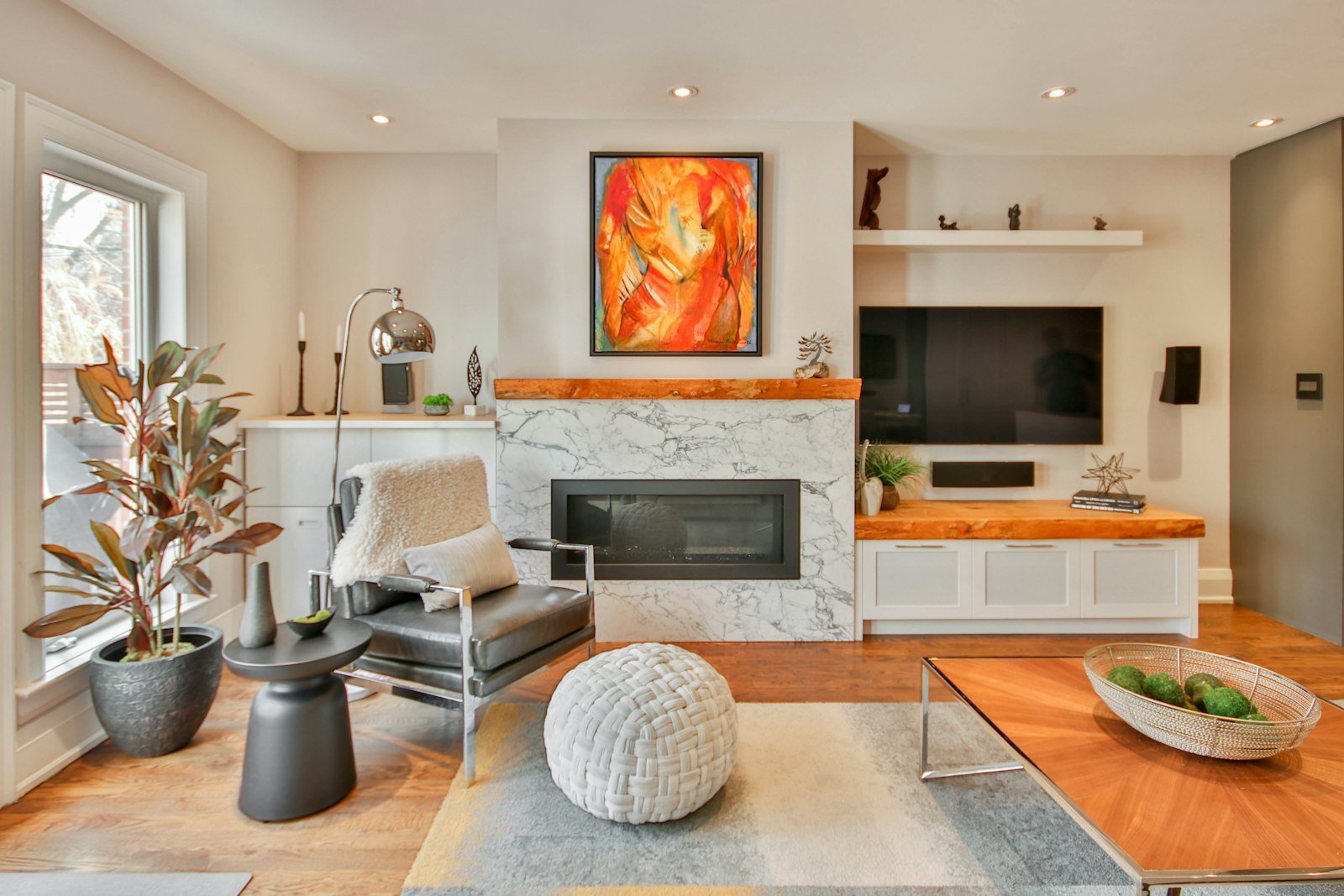 Best electric fireplace setup: a slim linear fireplace in a stone surround next to a wall-mounted TV in a bright living room