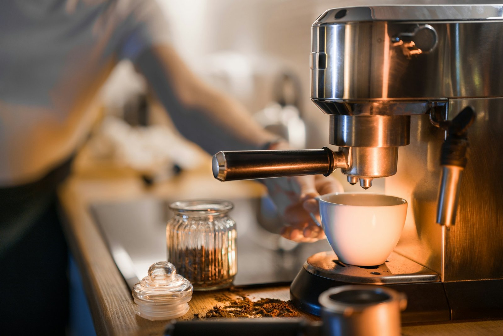 Espresso machine with grinder on a home kitchen counter pulling a shot into a white cup