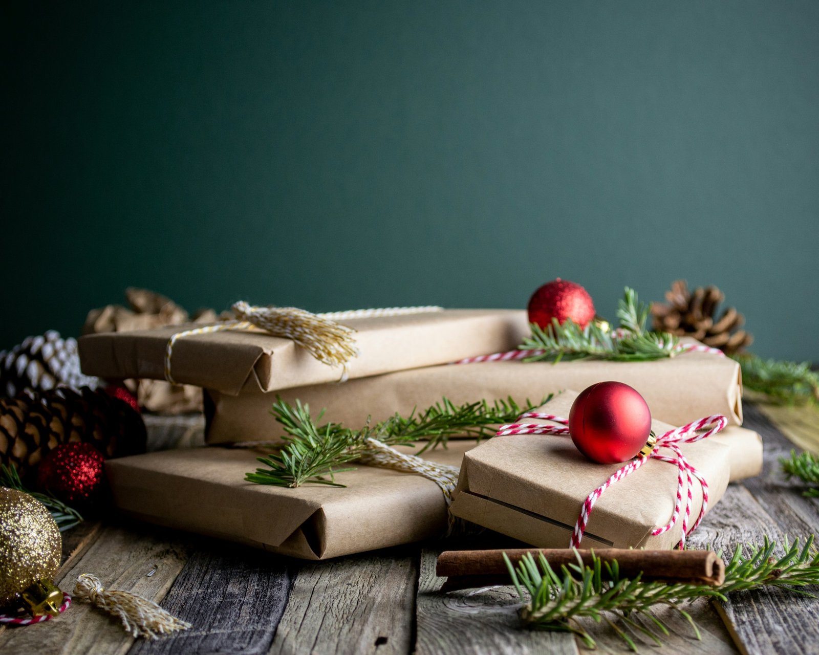Gift wrap organizer ideas: kraft-paper wrapped Christmas gifts with red ornaments and pine