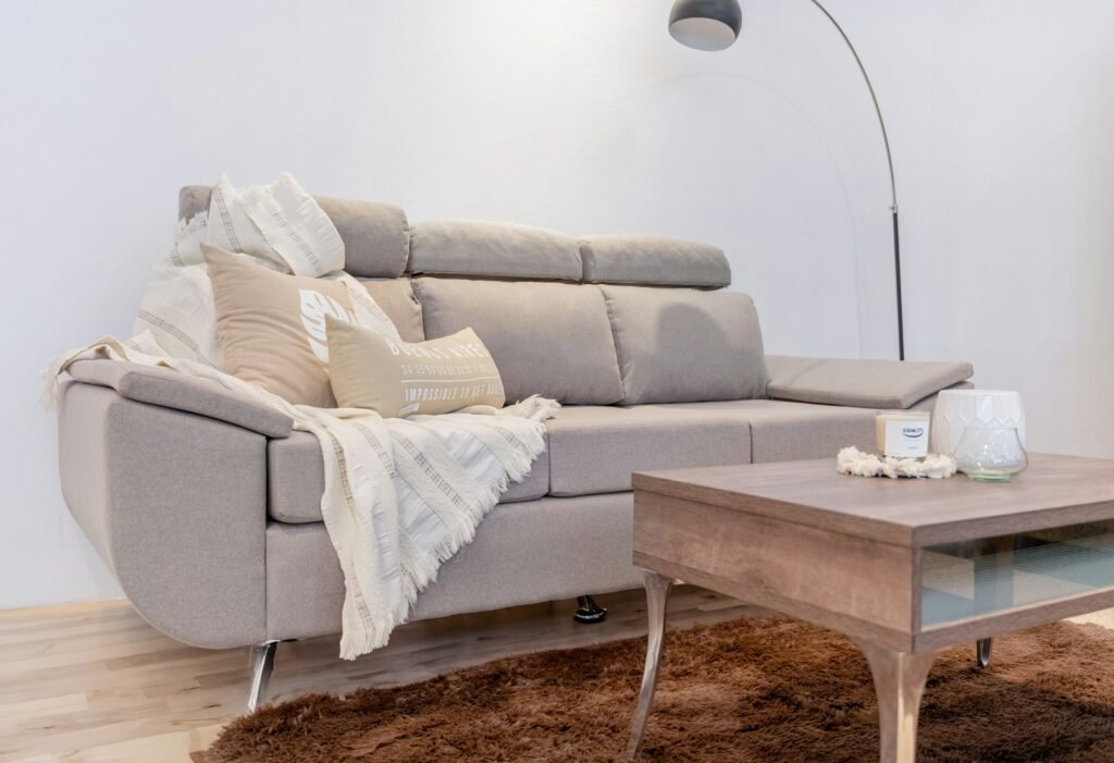Best heated throw blanket spot: a cream fringed throw on a light gray sofa in a bright living room