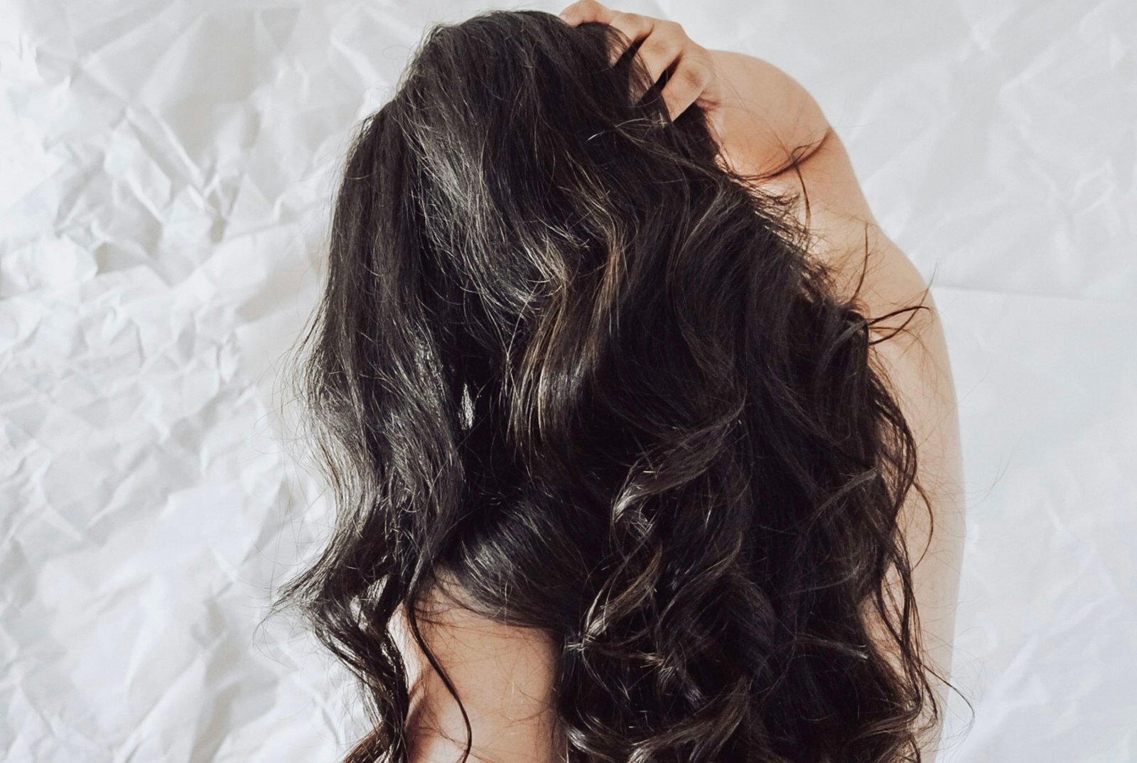 Best curling iron for long hair: long dark hair styled in loose, glossy waves