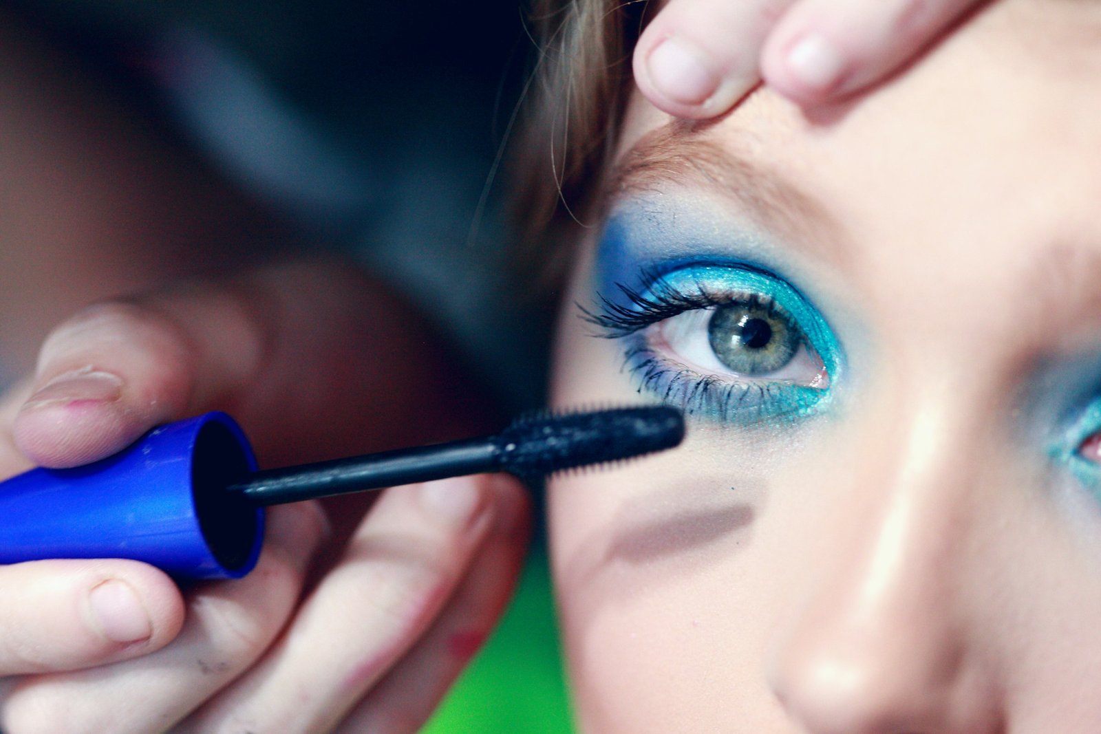 Best luxury mascara for length and volume: a makeup artist applying mascara to upper lashes