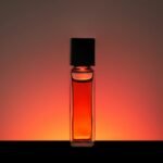 Luxury perfume oil roll on: a slim glass perfume oil bottle glowing amber against a warm backdrop