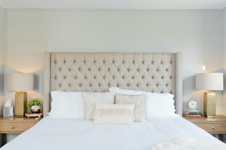 Best mattress protector guide: a neatly made bed with crisp white bedding and a tufted headboard