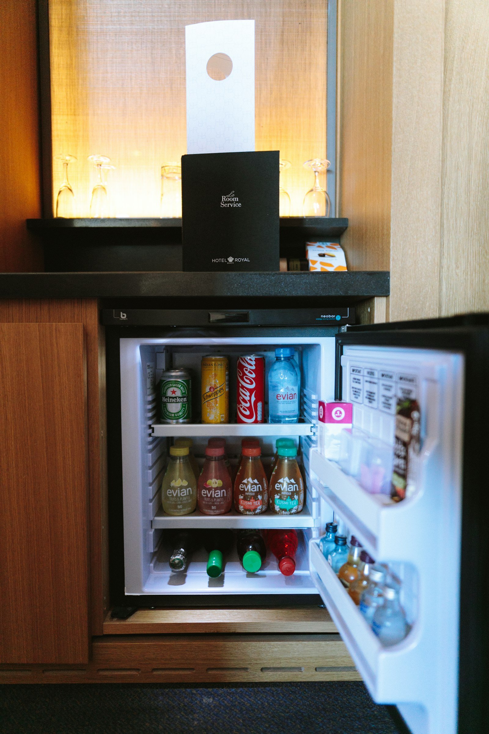 Best mini fridge for a bedroom or home office: an open compact refrigerator stocked with drinks under a counter