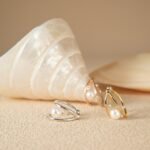 Best pearl stud earrings in gold and silver resting beside a seashell