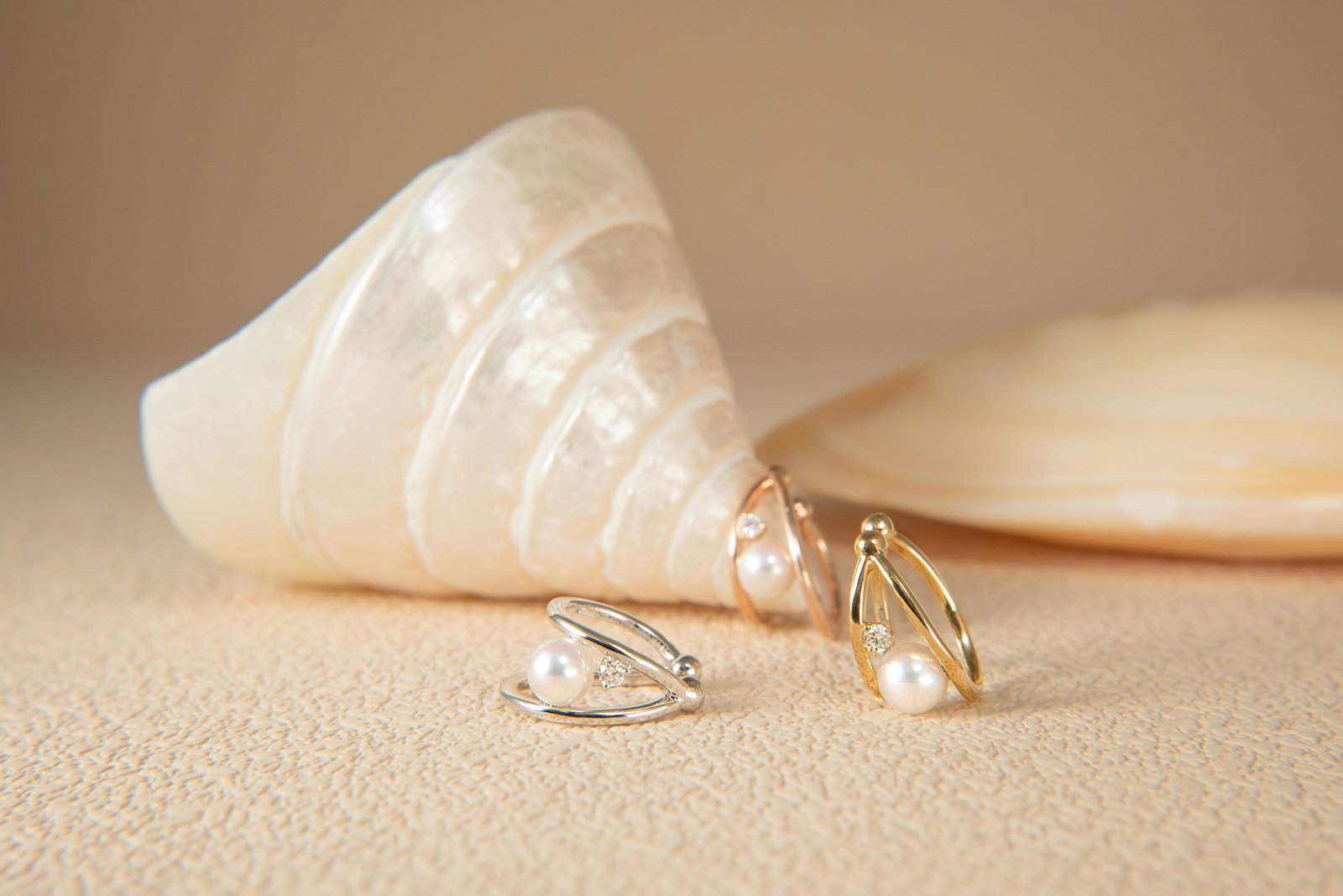 Best pearl stud earrings in gold and silver resting beside a seashell