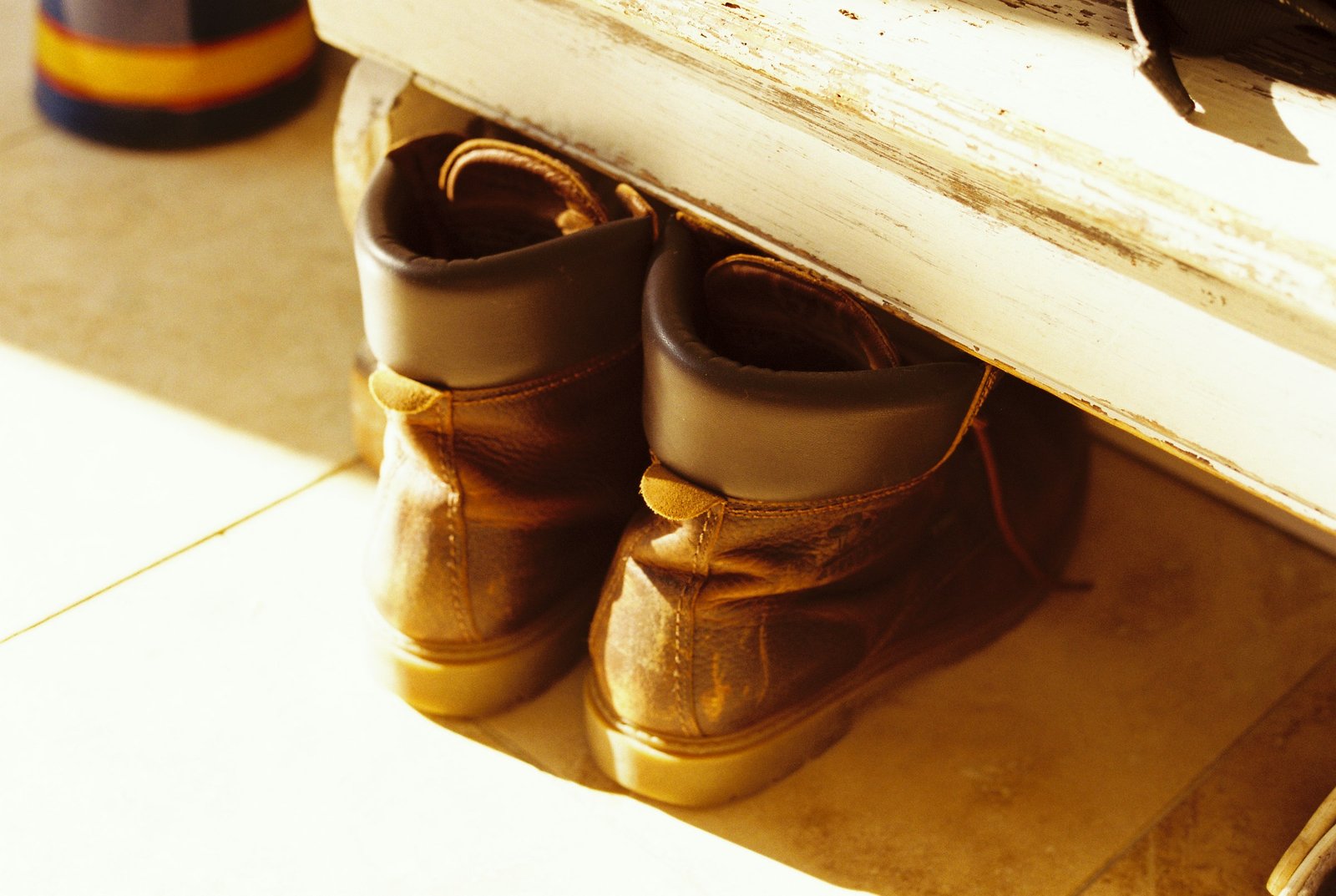 Boot tray for entryway idea: winter boots resting under a bench by the door