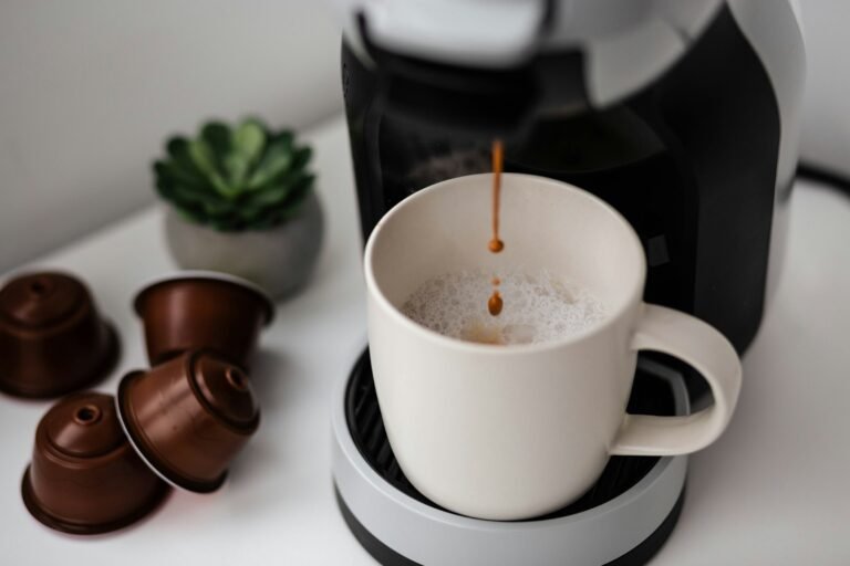 Best single serve coffee maker brewing into a white mug with coffee capsules on the counter