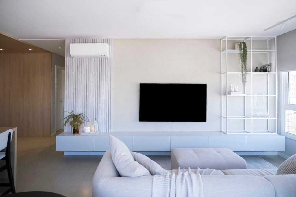 Low-profile white media console under a large TV, an example of a TV stand for small living room and big-screen setups