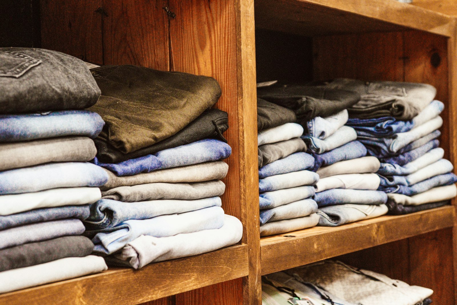 Stacks of folded clothes on wooden shelves, the off-season load that under bed storage containers can take off your closet