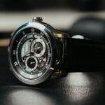 Best watch winder for automatic watches: an open-heart automatic watch with a black leather strap resting on a dark surface