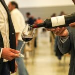 Best wine aerator pourer: red wine poured from the bottle into a large wine glass at a tasting