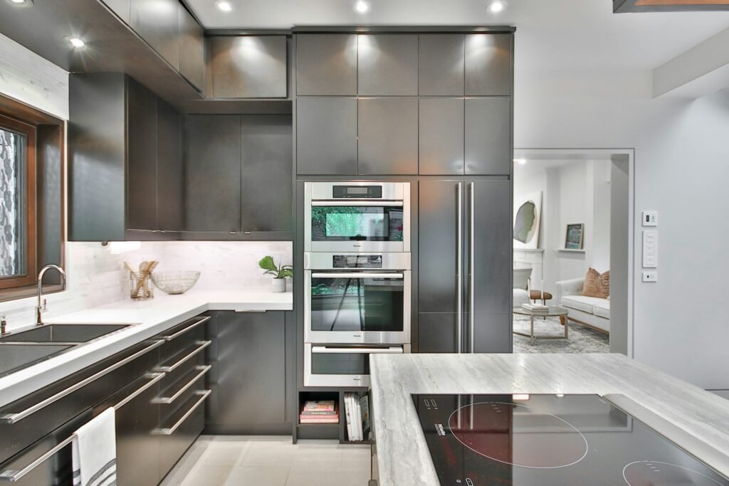 Black Friday kitchen deals: a modern kitchen with built-in ovens, a cooktop island and stone counters