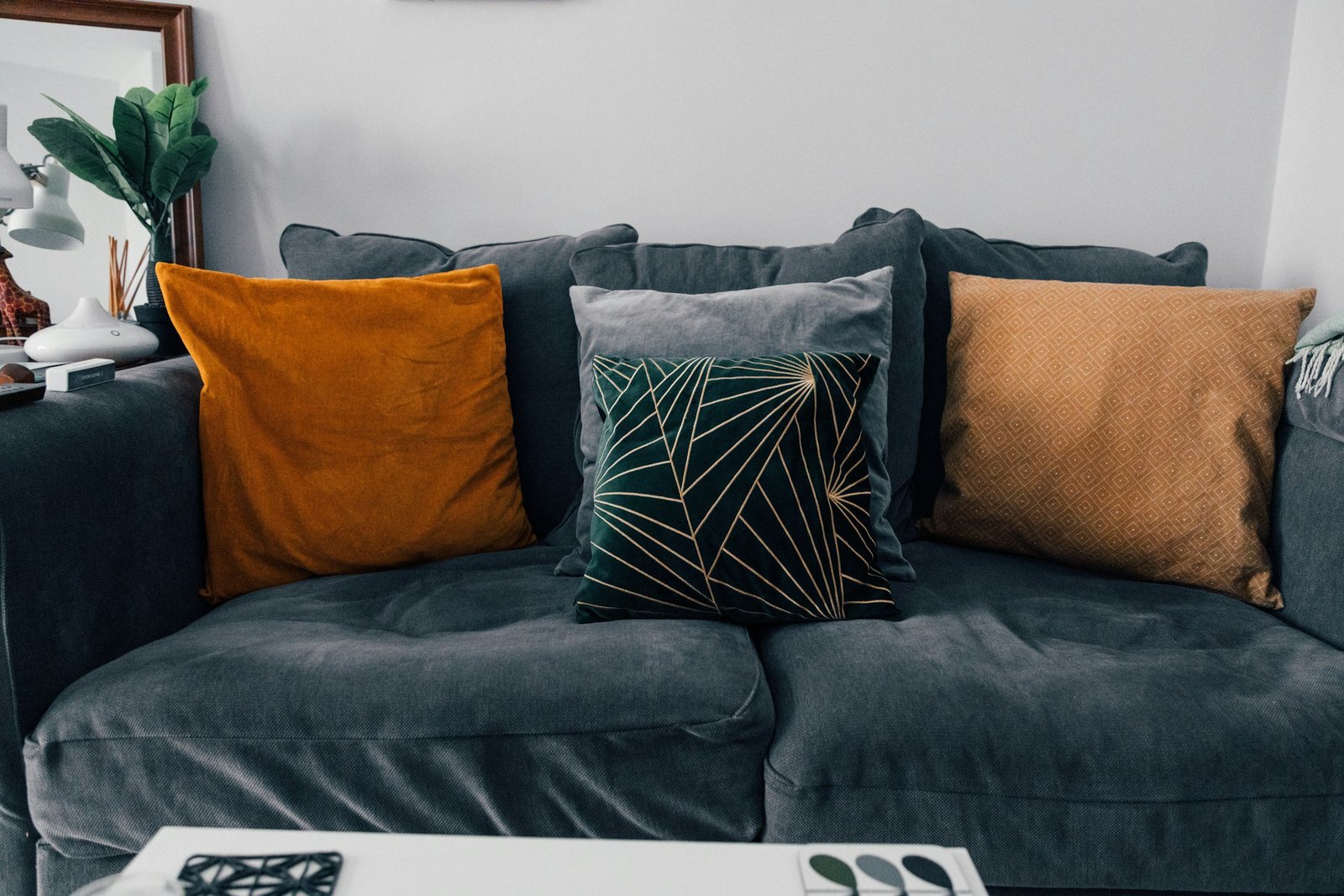 Chenille pillow covers idea: burnt orange and caramel pillows on a gray velvet sofa