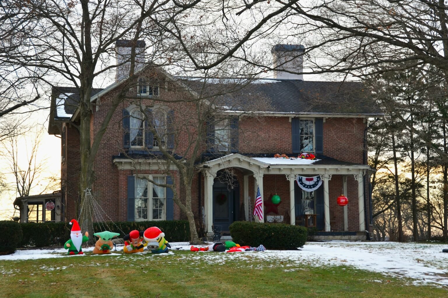 Christmas gnome topiary mood: a brick house decorated with gnomes and lights