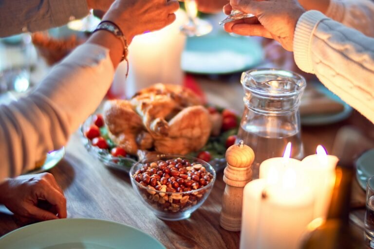 How much does it cost to host a Christmas party at home: guests toasting at a festive dinner table