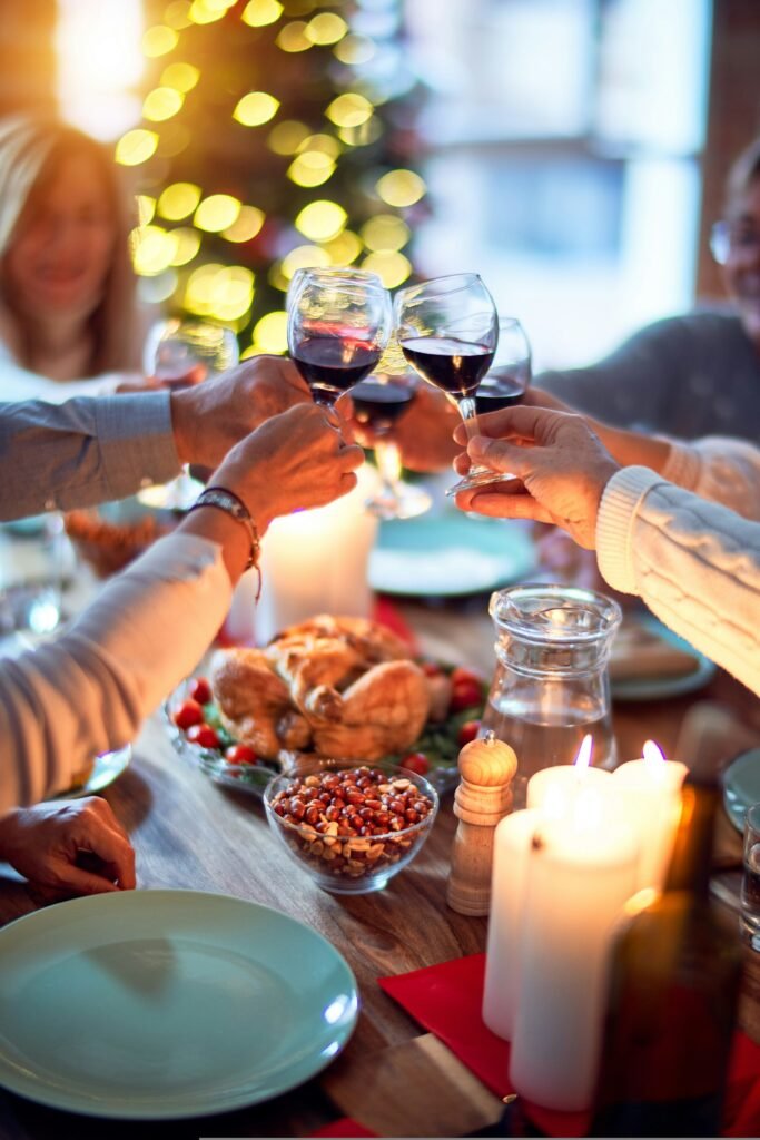 Christmas party budget: friends toasting with red wine over a festive dinner table at home