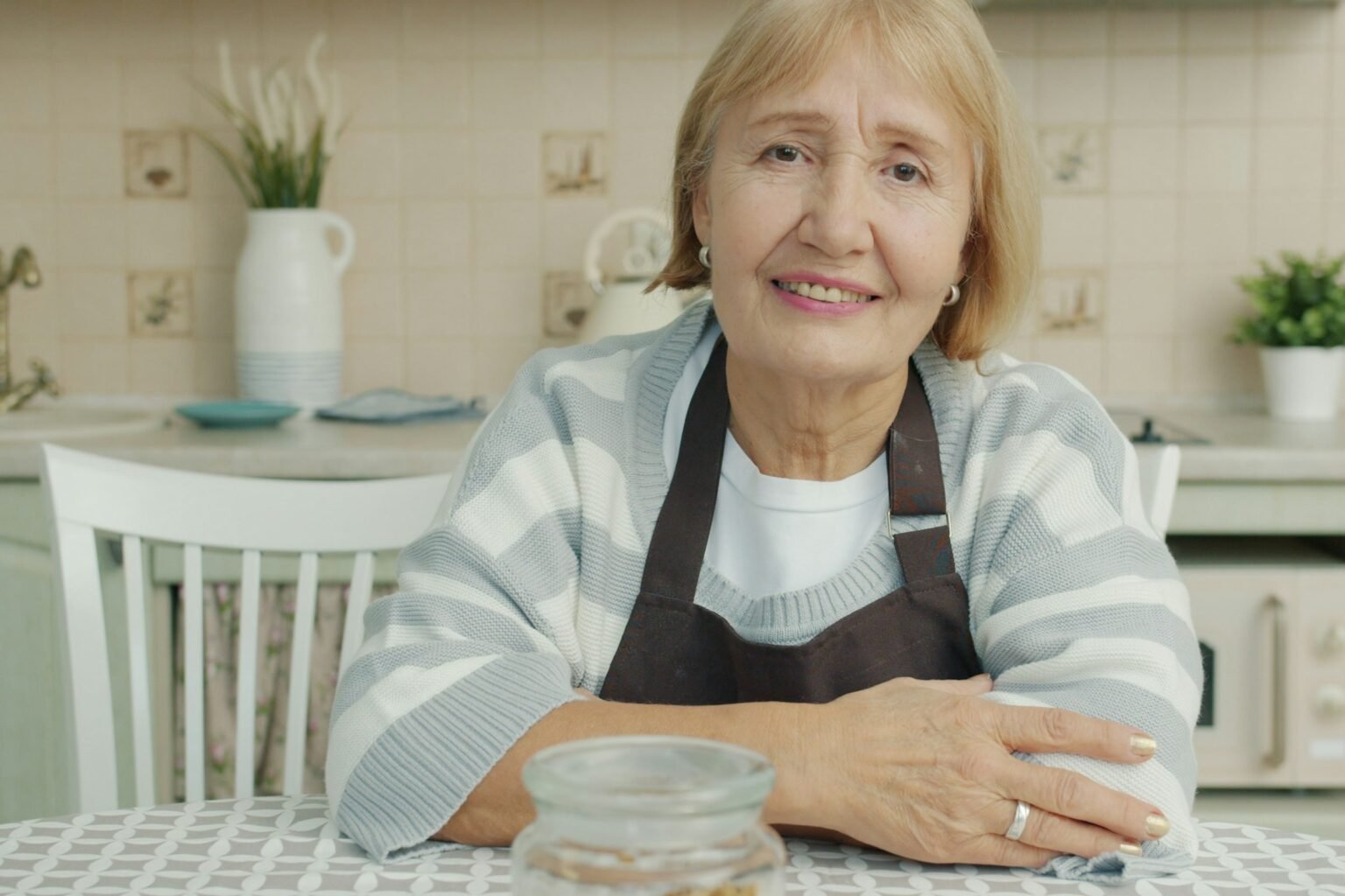 Day and date clock for elderly parents: a smiling senior woman at her kitchen table