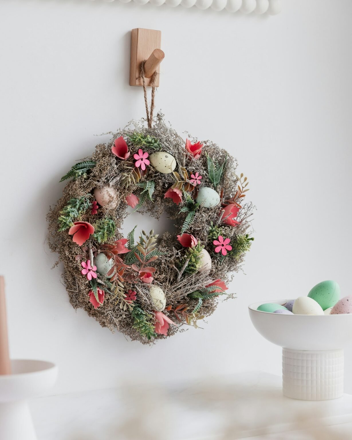 A spring wreath next to a bowl of eggs