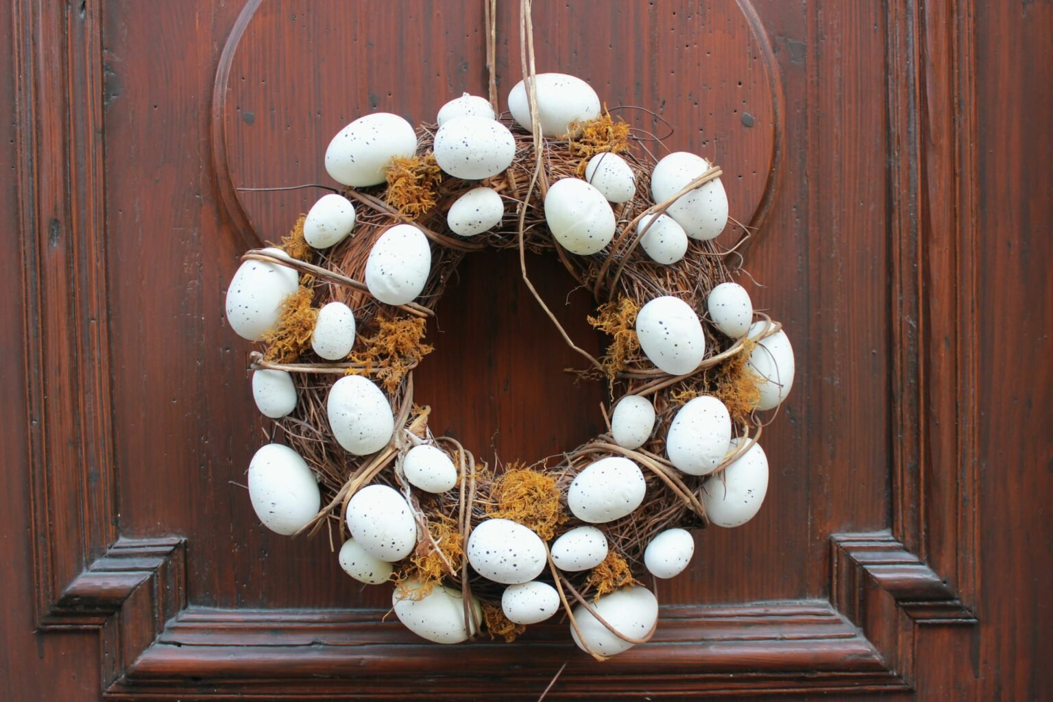 DIY Easter wreath made of eggs hanging on a wooden door