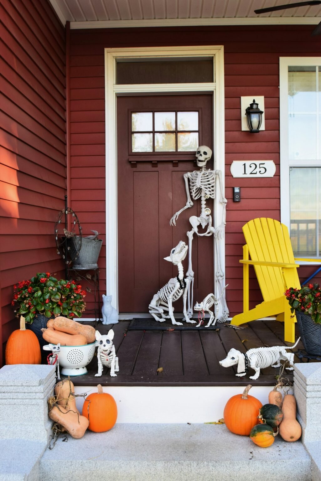Front porch decorated for Halloween with skeletons and pumpkins