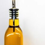 EJGIEGSO olive oil dispenser review: close-up of a stainless steel pour spout on a bottle of olive oil