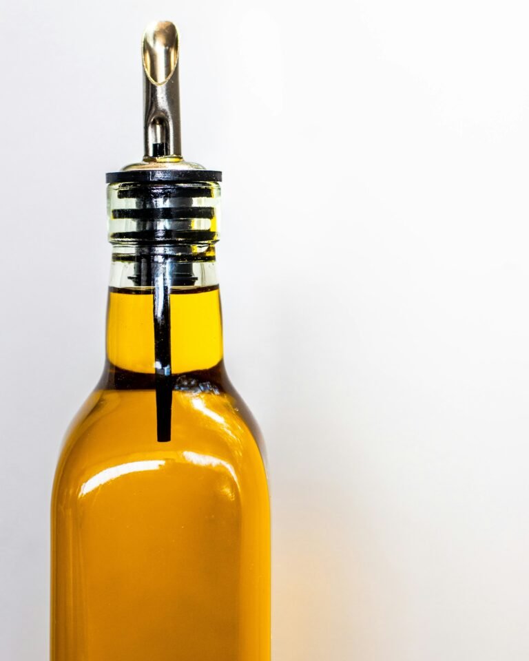 EJGIEGSO olive oil dispenser review: close-up of a stainless steel pour spout on a bottle of olive oil