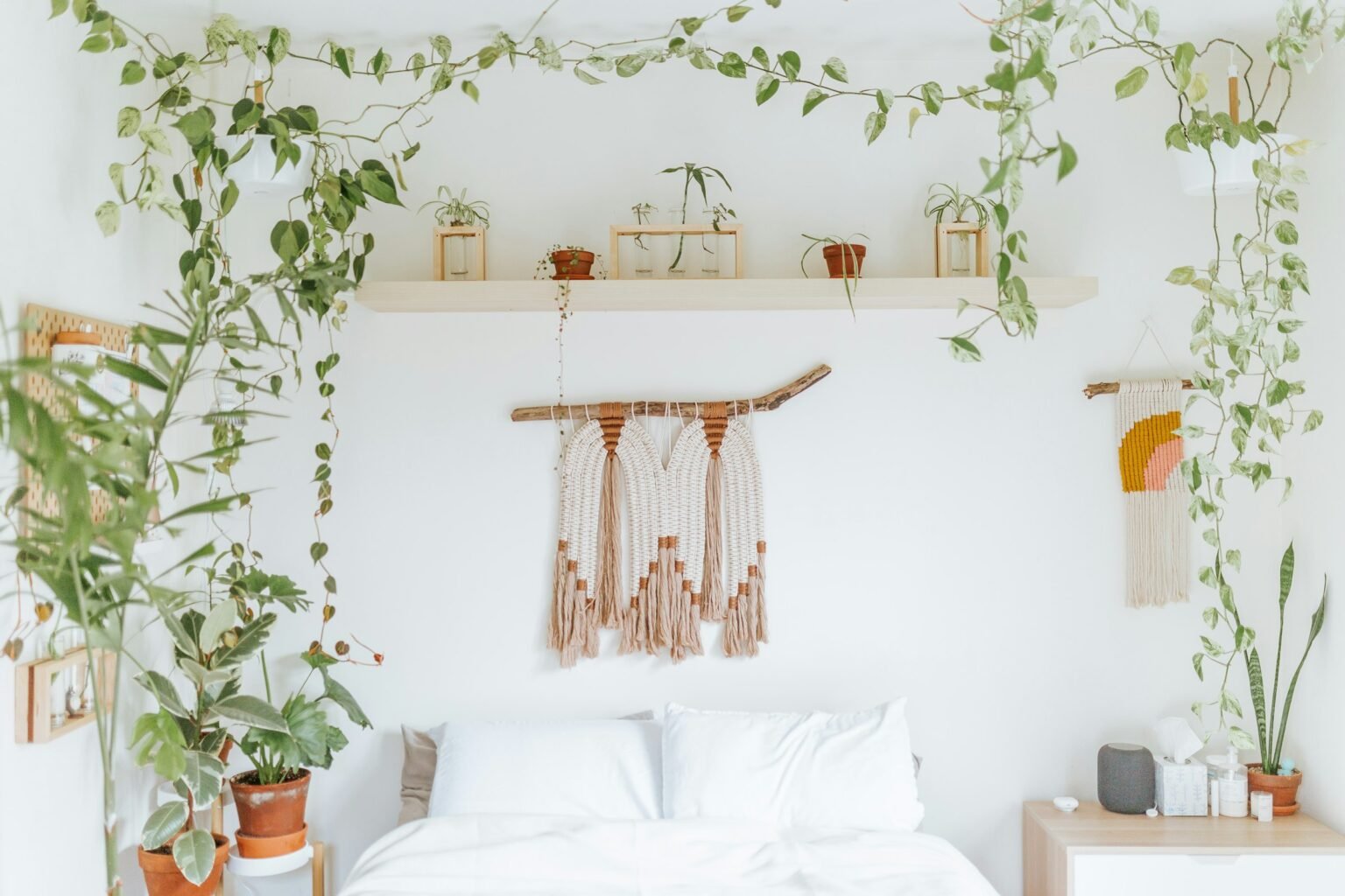 Fake ivy vines idea: trailing greenery over a shelf above a bright white bed