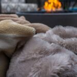 Faux fur throw for couch and patio lounging: soft taupe and cream faux fur blankets piled up on a chilly evening