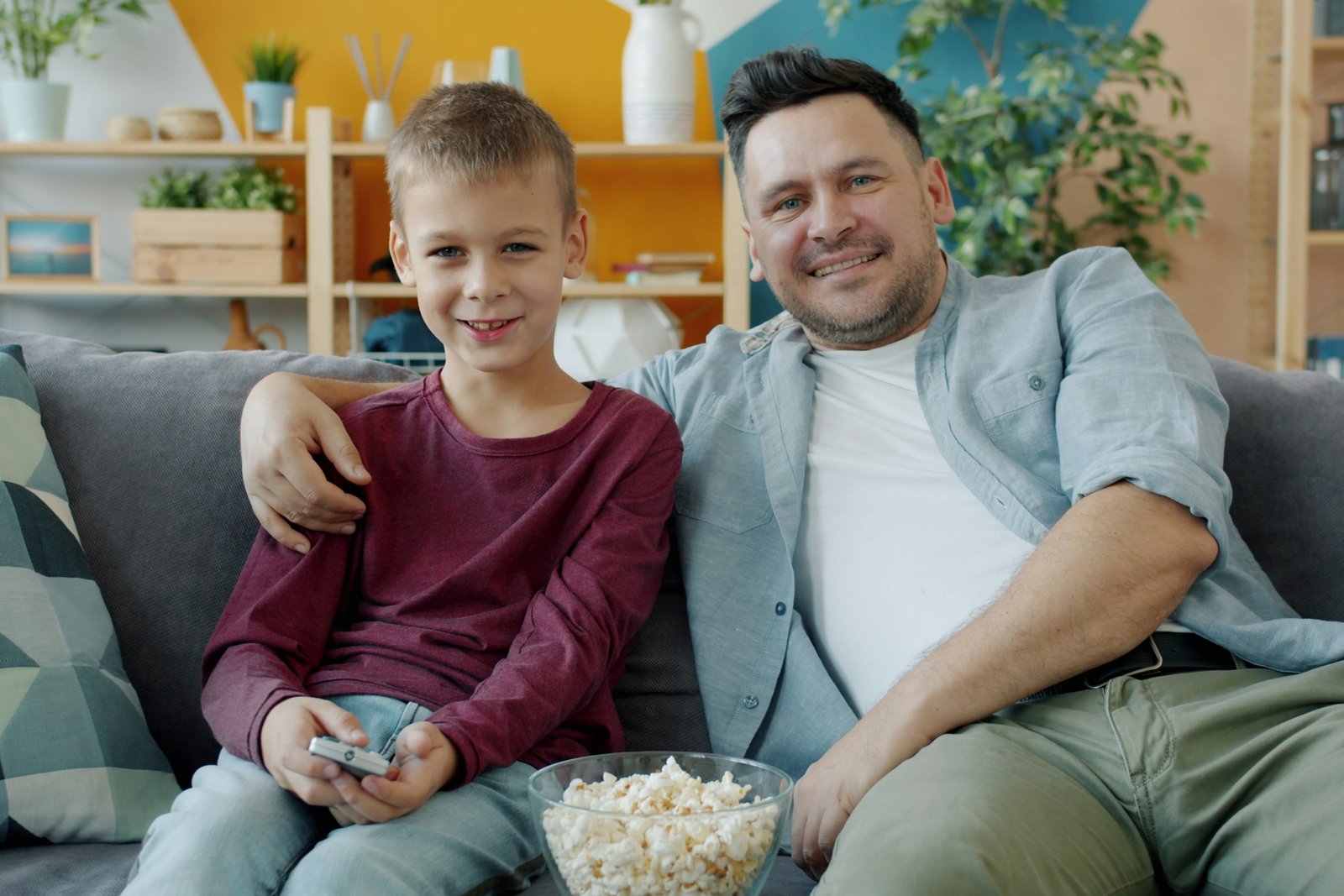 Folding snack tables idea: father and son on the couch with popcorn for movie night