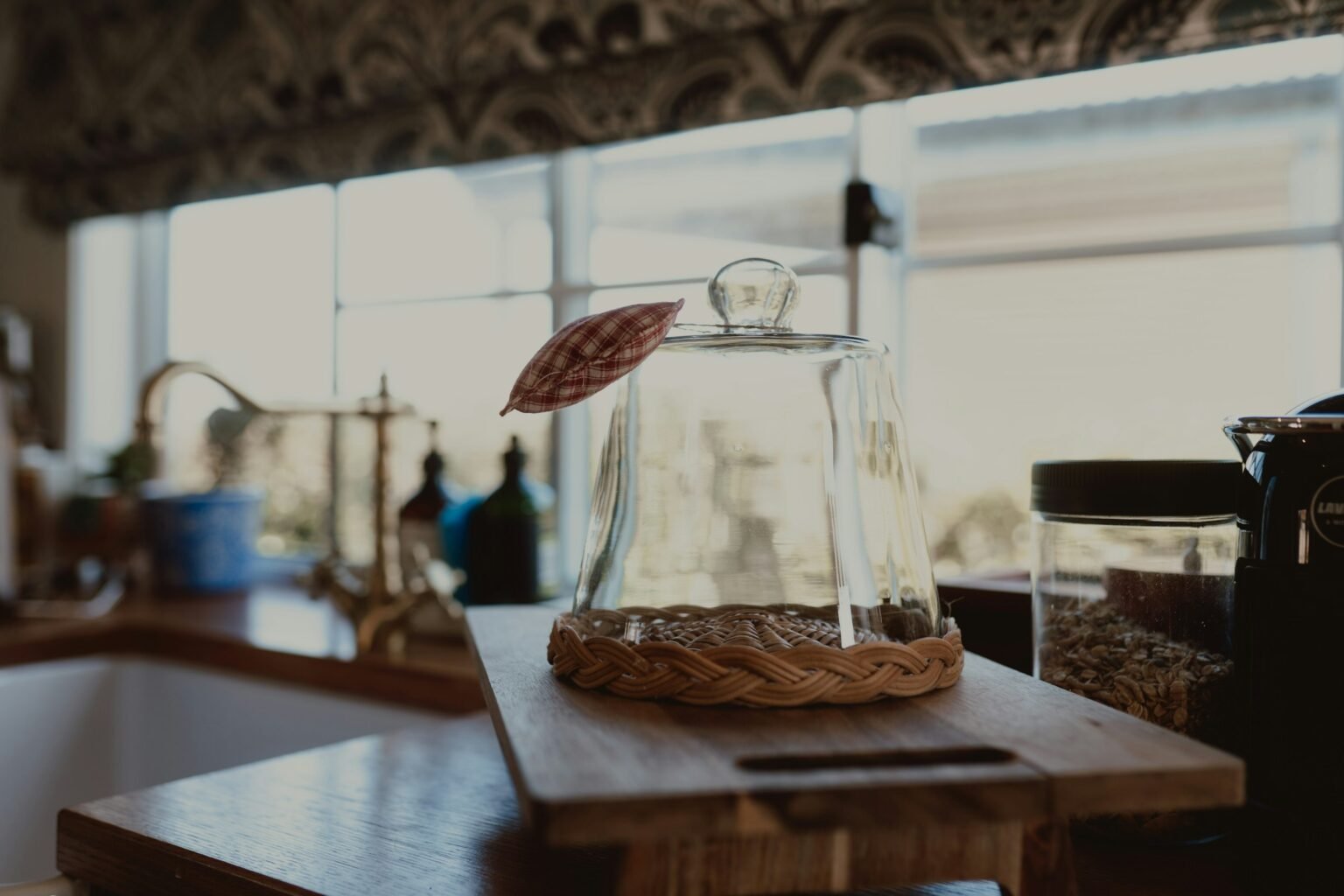 What to put in a glass cloche: a pastry under a glass dome on a woven tray in a bright kitchen