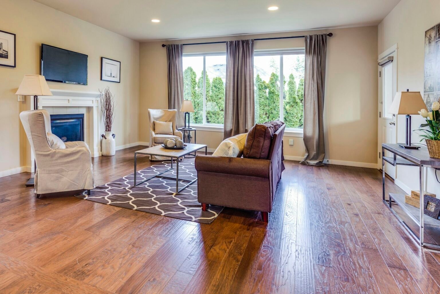 A living room with a fireplace and wood floor