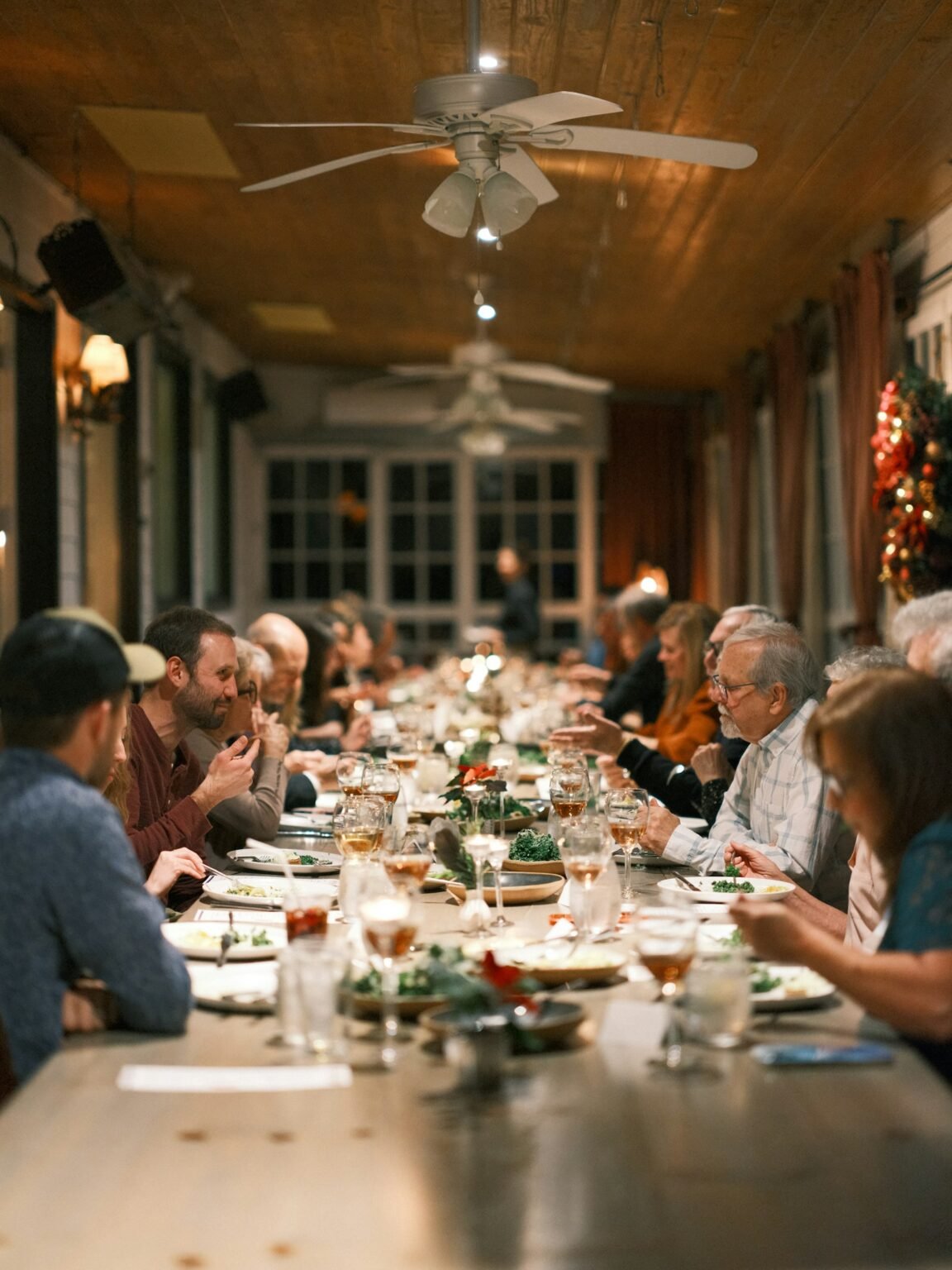Friends sitting at a long Thanksgiving dinner table
