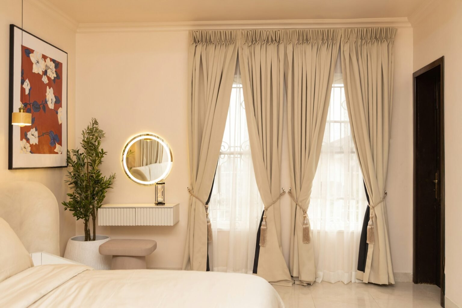 Linen blackout curtains for bedroom windows: long neutral panels hung high above a calm, cream bedroom