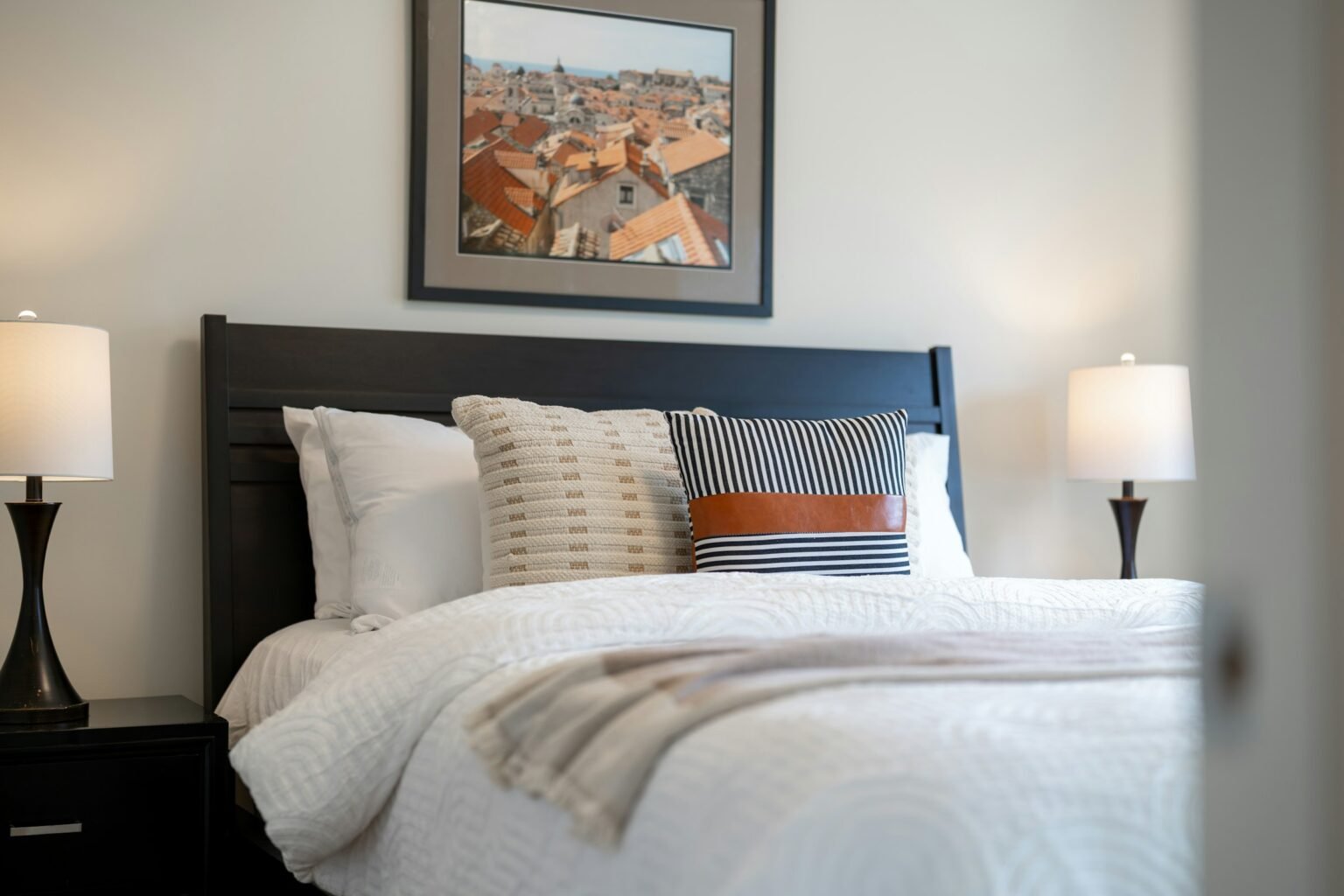 How to style lumbar pillow on bed: a striped lumbar pillow layered in front of white sleeping pillows