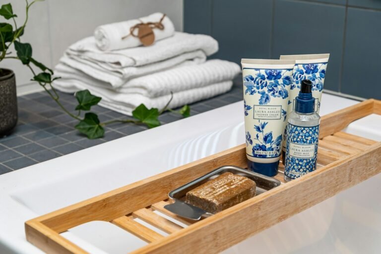 Luxury bath gift sets: shower cream, body mist and soap on a bamboo bath caddy with rolled white towels