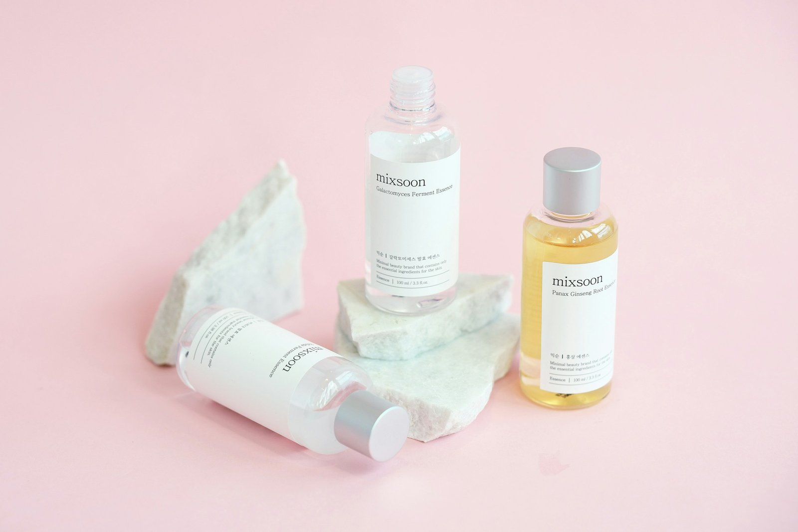 Korean skincare gift set for women: toner, essence and oil bottles arranged on white stones
